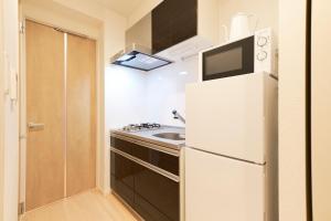 a kitchen with a white refrigerator and a sink at G-Stage 01 IKEBUKURO in Tokyo