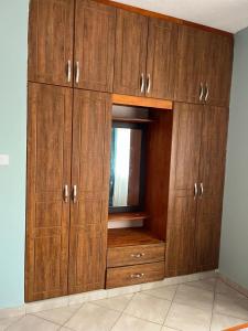 a large wooden cabinet with a window in a room at Vero Homes in Buwate