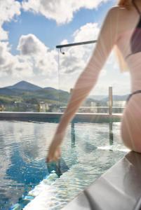 uma mulher está de pé numa piscina em Mountain Residence Apartments & Chalet em Bukovel