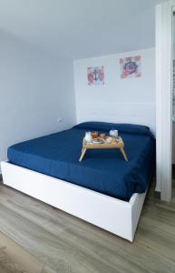 a bed with a blue blanket and a tray on it at Wishing & Dreaming Sperlonga in Sperlonga