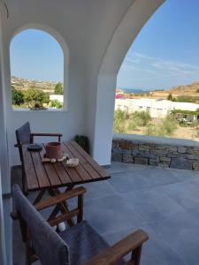 a wooden table and chairs in a room with a window at SIFNAIOU TRADITIONAL Houses 1 & 3 in Parikia