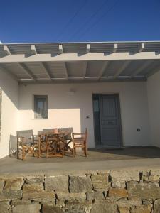 a patio with a table and chairs under a roof at SIFNAIOU TRADITIONAL Houses 1, 2, 3 in Parikia