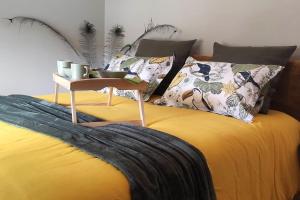 a yellow bed with a table on top of it at Jacuzzi au Lemon Tree et charme des pierres dorées in Panossas