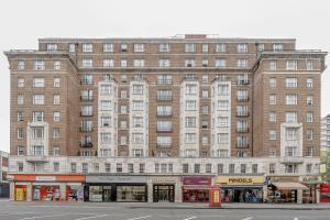 um grande edifício de tijolos com lojas em frente em Stunning Flat Next To Hyde Park em Londres