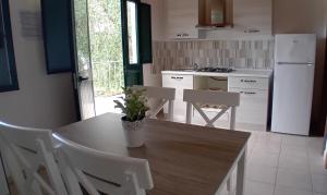 La cuisine est équipée d'une table, de chaises et d'un réfrigérateur. dans l'établissement Agriturismo Valle Dei Gelsi, à Peschici