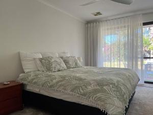 een slaapkamer met een groot bed en een raam bij The Duncraig House, Pet friendly in Perth