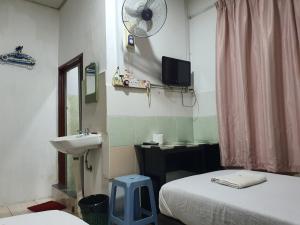 a bathroom with a bed and a sink and a mirror at OYO 90972 Jj Homestay in Miri