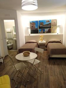 een kamer met twee bedden en een tafel erin bij DomuS al Corso B&B in Canosa di Puglia