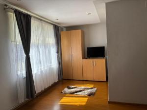 a living room with a large window and a wooden floor at Casa Otilia in Chişcău