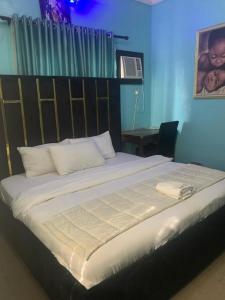 a bedroom with a large bed with a headboard at THE GROOVE GUEST HOUSE in Lagos