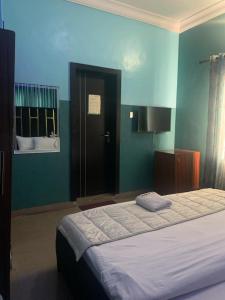 1 dormitorio con cama y pared azul en THE GROOVE GUEST HOUSE en Lagos