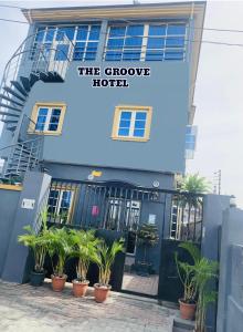 a hotel with potted plants in front of it at THE GROOVE GUEST HOUSE in Lagos
