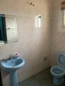 y baño con lavabo azul y aseo. en THE GROOVE GUEST HOUSE en Lagos