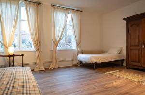 Un dormitorio con dos camas y dos ventanas. en Maison Monsigny, en Saint-Omer