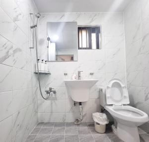 a white bathroom with a toilet and a sink at Stay Cheongnyang in Seoul