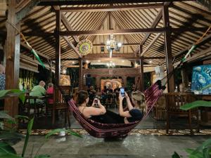 two girls sitting in a hammock in a restaurant at Bedhot Homestay in Yogyakarta