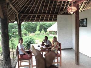 een groep mensen die aan een tafel zitten bij Melody Surf Camp - Ekas Lombok in Ekas