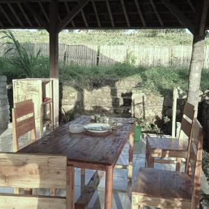 a wooden table and chairs under a pavilion at Melody Surf Camp - Ekas Lombok in Ekas