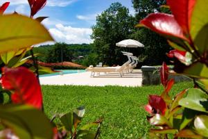 une personne assise sur un banc avec un parapluie dans l'établissement Locanda Fermento, à Mochignano