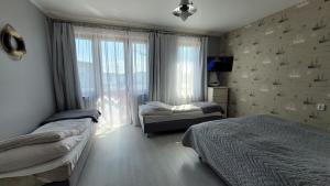 um quarto com 2 camas e uma janela em Amber em Mrzeżyno