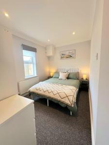 Schlafzimmer mit einem Bett und einem Fenster in der Unterkunft Bournemouth Beach Apartment in Bournemouth