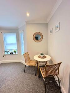 een kamer met een tafel en stoelen en een raam bij Bournemouth Beach Apartment in Bournemouth