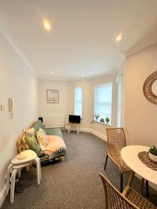 een woonkamer met een bank en een tafel bij Bournemouth Beach Apartment in Bournemouth