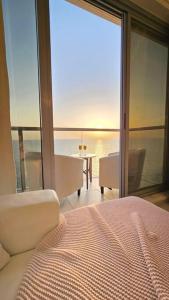 a bedroom with a bed and a view of the ocean at Luxury Ocean Front Apartment in Ras al Khaimah