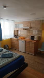 ブダペストにあるDeniz Guesthouseのキッチン(木製キャビネット付)、ベッド1台が備わります。