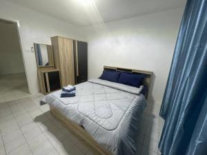 a bedroom with a large bed with blue pillows at Na kluea family stay in Pattaya North