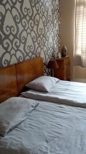 um quarto com uma cama e uma parede com um padrão em Cosy em Vršac