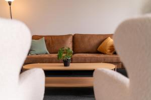 a living room with a couch and a table with a plant at Uppsala Hotel Apartments in Uppsala