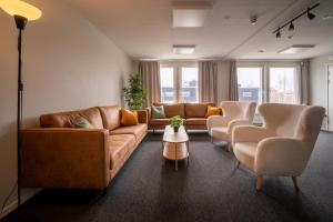 ウプサラにあるUppsala Hotel Apartmentsのリビングルーム(ソファ、椅子、テーブル付)