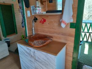 uma cozinha com um lavatório numa pequena casa em Tree house Ramona & Fairytale wooden house by Ljubljana em Grosuplje