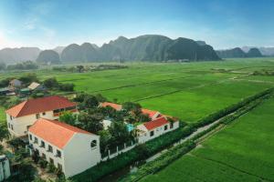 una vista aérea de un pueblo con montañas en el fondo en Dong Ne Tam Coc Hotel & Resort en Ninh Binh