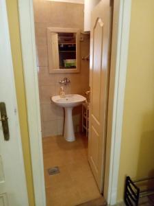 uma casa de banho com um lavatório branco e um espelho. em Cosy em Vršac
