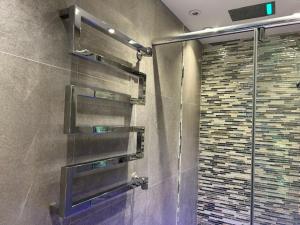 a shower with a glass door in a bathroom at Pop Art Luxury Room Marylebone in London