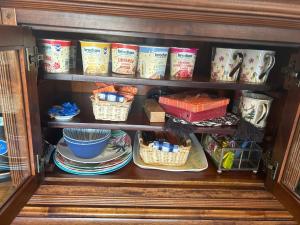 a cupboard with plates and baskets and dishes in it at The Guest suite at Daviot ,Inverness in Inverness