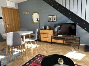 a living room with a table and a tv at Apartamenty Zamość Sienkiewicza in Zamość