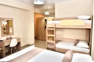 a bedroom with two bunk beds and a desk and a desk at GREEK PRIDE PANTHEA STUDIOS in Skala Fourkas +6 photos