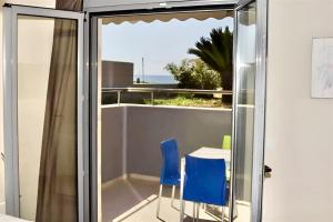 a room with a table and two blue chairs at GREEK PRIDE PANTHEA STUDIOS in Skala Fourkas