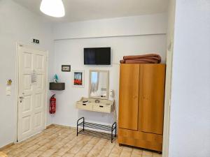 a room with a wooden cabinet and a mirror at LORA STUDIOS in Ýpsos