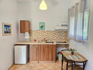 a small kitchen with a sink and a table at LORA STUDIOS in Ýpsos