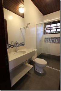a bathroom with a sink and a toilet at Velas Chalés in Ubatuba