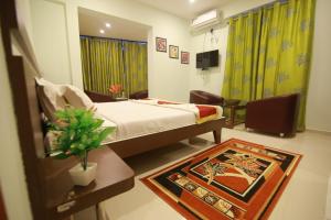 a bedroom with a bed and a table with a rug at golden residency Mysore in Mysore