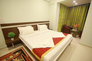 a bedroom with a bed and a table and a window at golden residency Mysore in Mysore