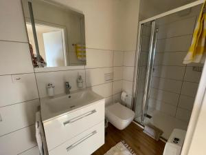 a bathroom with a sink and a toilet and a mirror at Residenza Bettina BnB & Ferienwohnungen in Ronco s/Ascona - Porto Ronco +79 photos