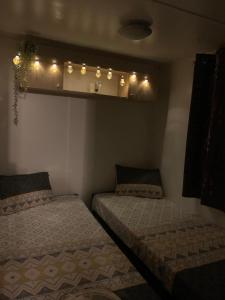 2 camas en una habitación con luces en la pared en Camping les Goélands Bassin d'Arcachon 3 chambres Luxe, en Arès