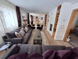 ein Wohnzimmer mit einem Sofa und einem Tisch in der Unterkunft Spacious Family Apt Flims close to Lake Cauma in Flims