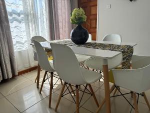 a dining room table with a vase of flowers on it at Hi-Life Villa in Gaborone